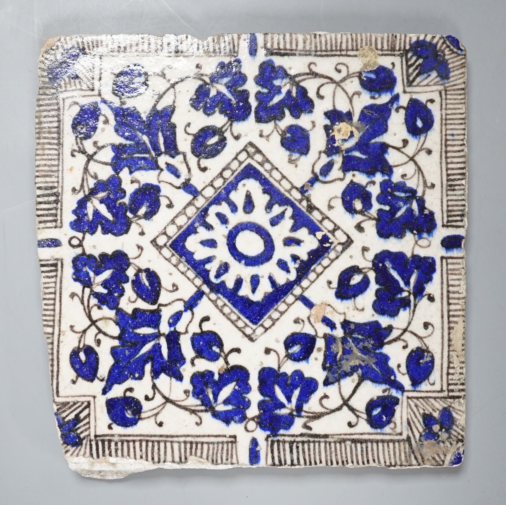 A Persian blue and white ceramic tile - 21 x 20cm